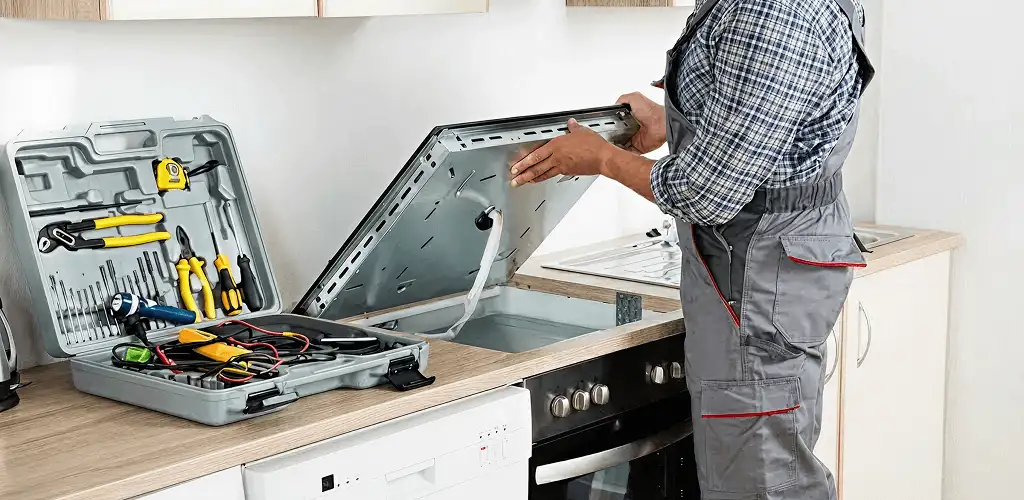 Handyman repairing a cooktop and checking wiring connections in Columbus, OH