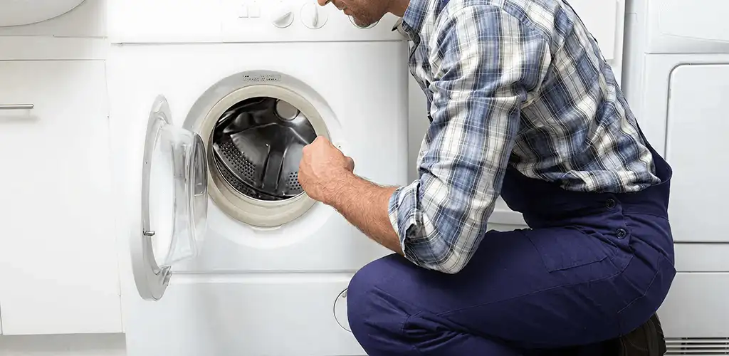 Handyman inspecting a dryer drum and internal parts for repair in Columbus, OH