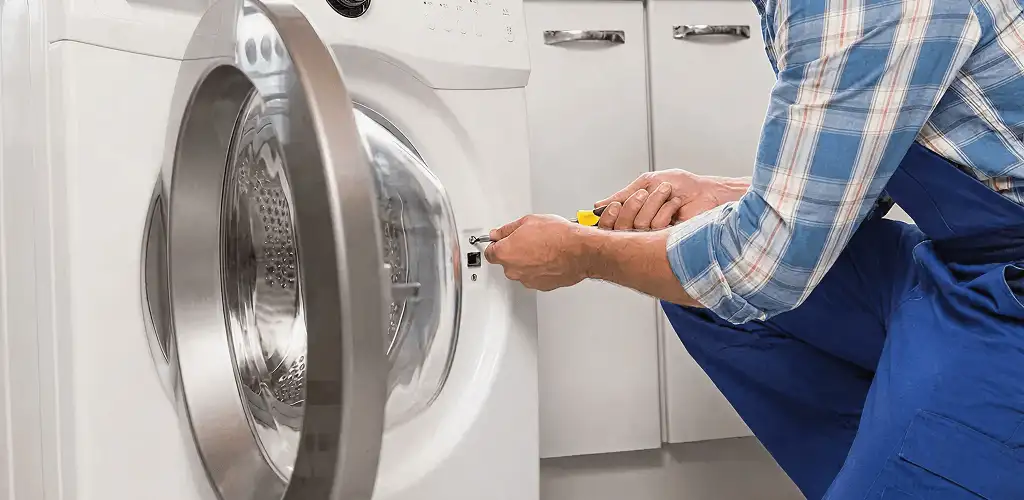 Handyman repairing a clothes dryer and checking electrical connections in Columbus, OH