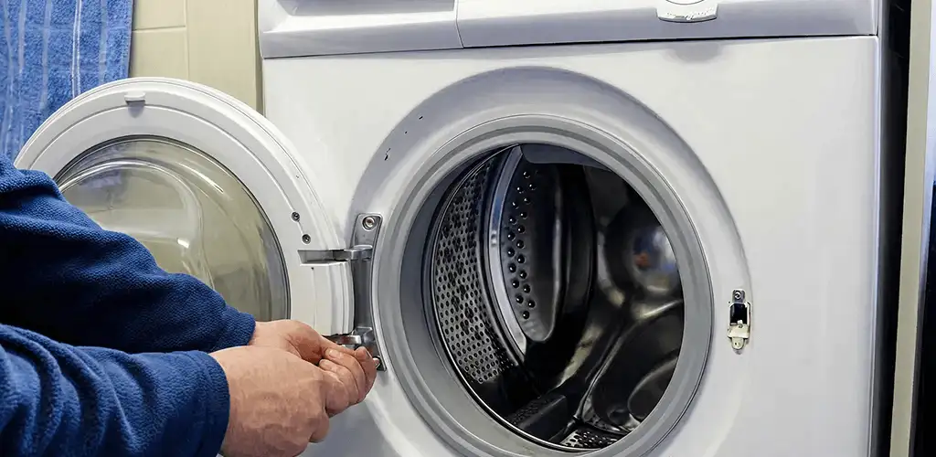 Washing machine repair handyman checking a front-load washer door and latch in Columbus, OH