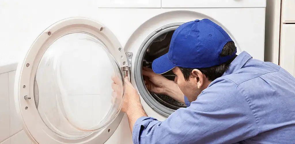 Washing machine repair handyman inspecting a front-load washer drum in Columbus, OH