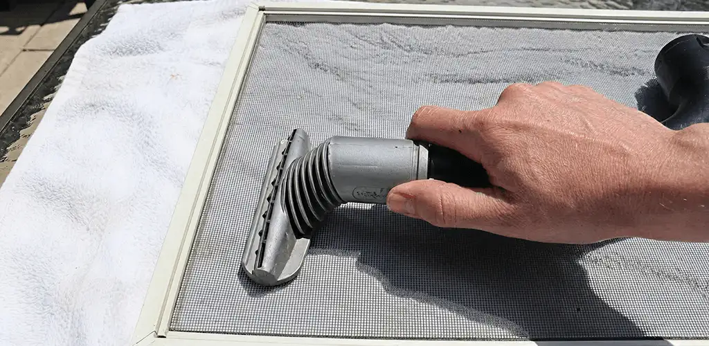 Window screen repair cleaning and fixing a damaged screen mesh in Columbus, OH